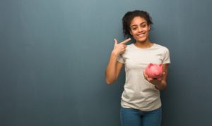 woman with a dental savings plan pointing to her smile 