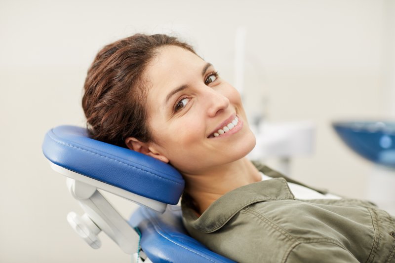 person at dentist’s office smiling after tooth extraction