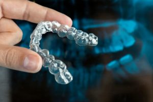 close up of hand holding ClearCorrect aligner
